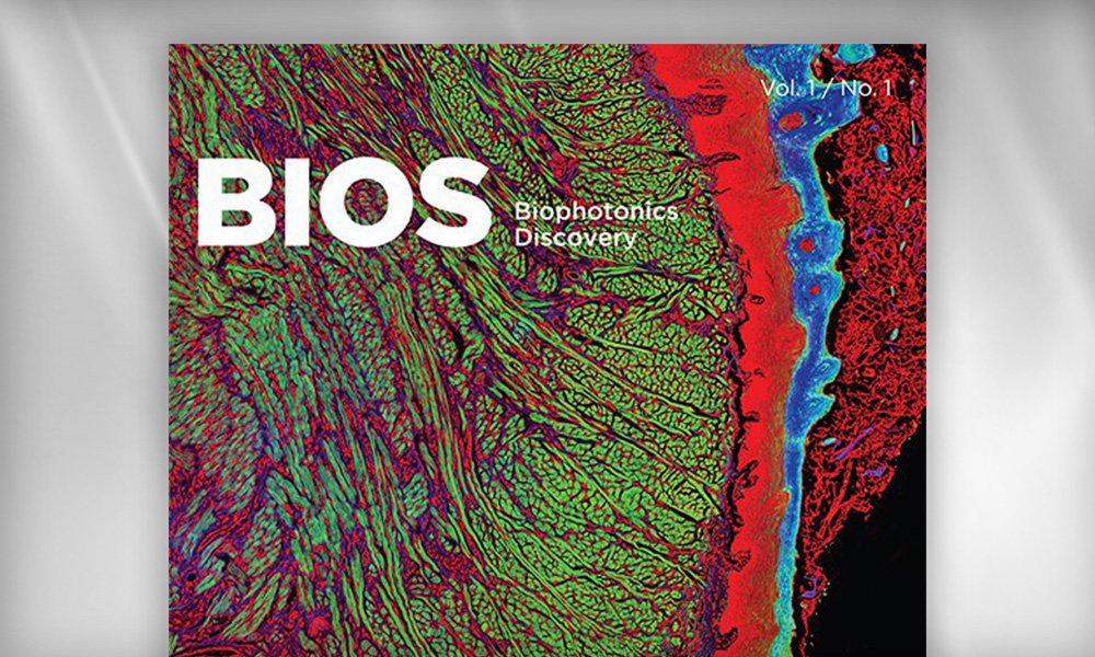 SPIE Journal cover for Biophotonics Discovery, featuring a colorful microscopic image of biological structures in green, red, and blue, representing biophotonics research.